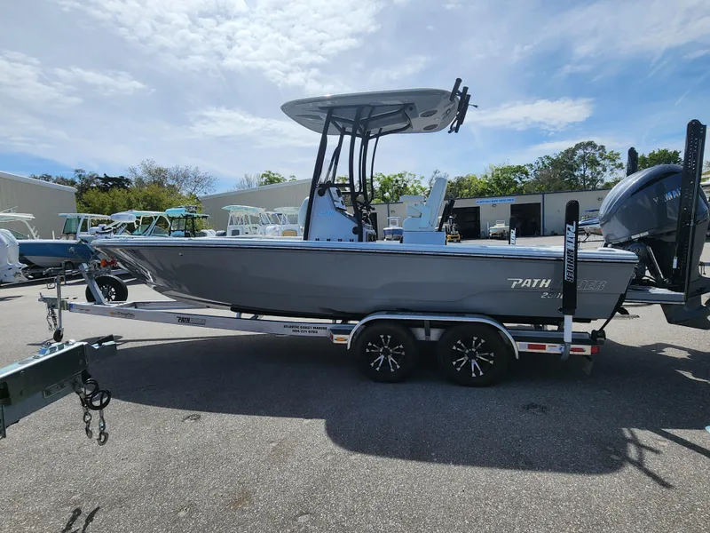 Slide: The Image of 2023 Pathfinder 2500 Hybrid boat on trailer, parked outdoors under cloudy sky. - 3