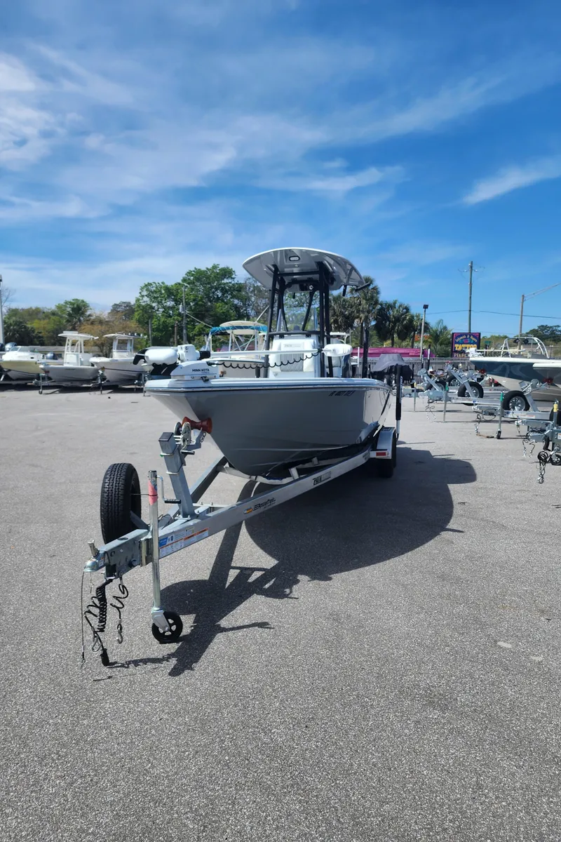 Slide: The Image of 2023 Pathfinder 2500 Hybrid boat on trailer under clear blue sky. - 5