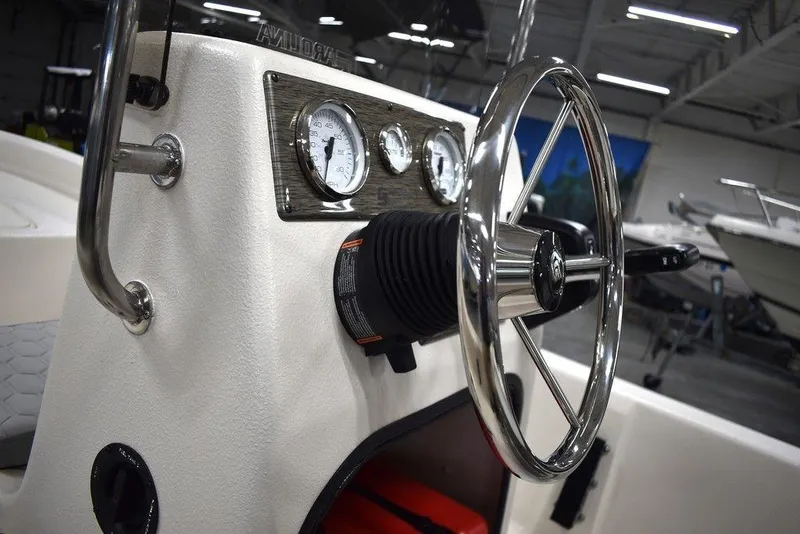 Slide: The Image of 2025 Carolina Skiff E20 JVX Center Console steering wheel and gauges in a showroom. - 25
