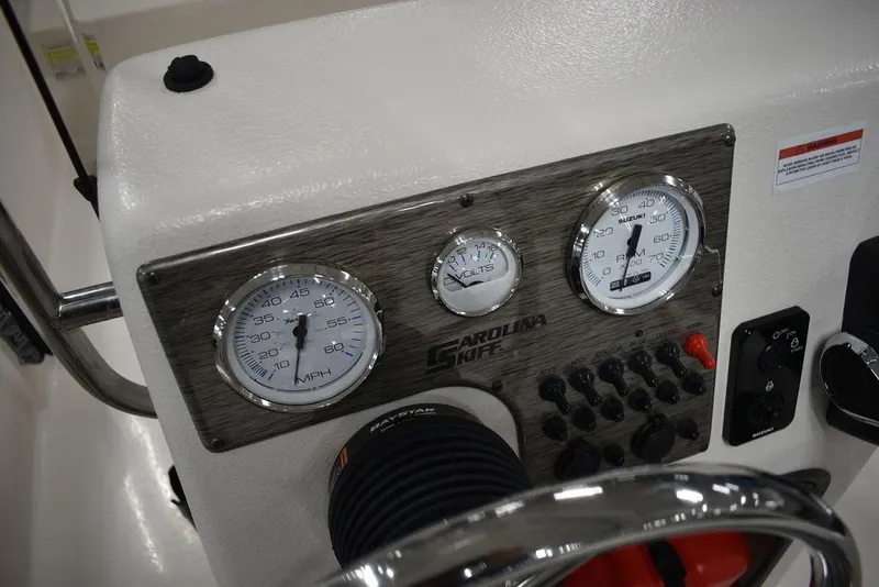 Slide: The Image of 2025 Carolina Skiff E20 JVX Center Console dashboard with gauges and controls. - 26