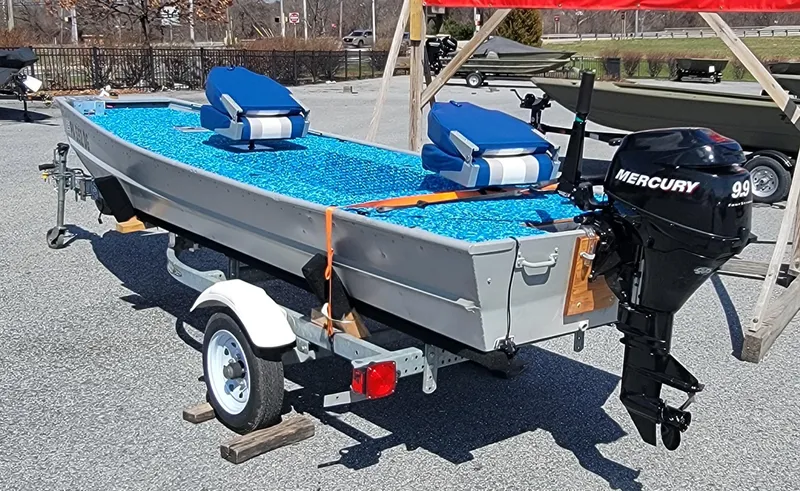 Slide: The Image of 2011 Tracker Topper 1436 Riveted Jon boat with Mercury 9.9 motor on trailer. - 2