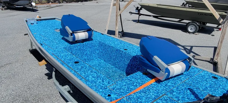 Slide: The Image of 2011 Tracker Topper 1436 Riveted Jon boat with blue seats on a trailer. - 3
