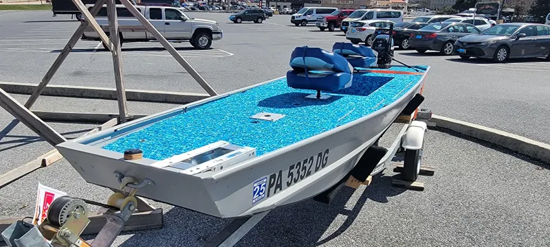 Slide: The Image of 2011 Tracker Topper 1436 Riveted Jon boat on trailer in parking lot. - 4