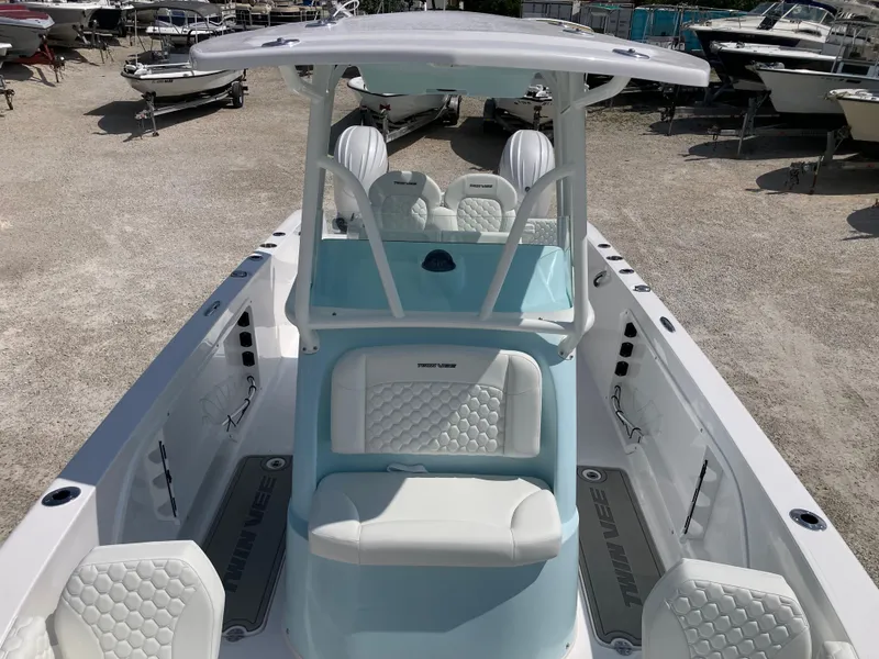 Slide: The Image of 2025 Twin Vee 240GFX boat with white seating and sleek design in a boatyard. - 11