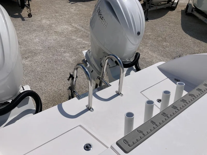 Slide: The Image of 2025 Twin Vee 240GFX boat deck with dual engines and fishing rod holders. - 14