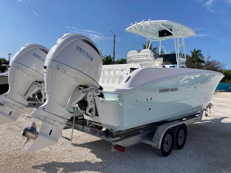 Slide: The Image of 2025 Twin Vee 240GFX boat with dual Yamaha engines on a trailer, parked outdoors. - 3