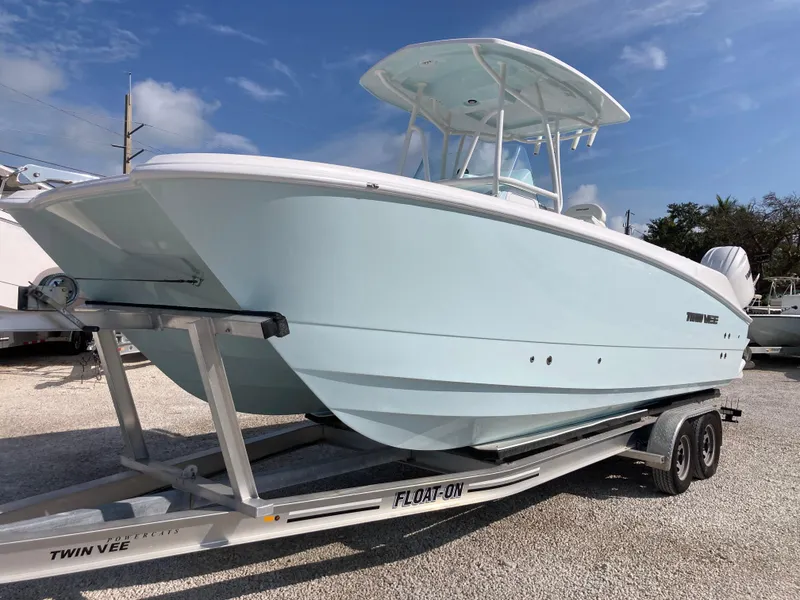Slide: The Image of 2025 Twin Vee 240GFX boat on trailer, light blue hull, sunny day. - 5