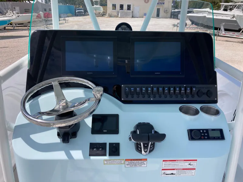 Slide: The Image of 2025 Twin Vee 240GFX boat dashboard with dual screens and steering wheel. - 8