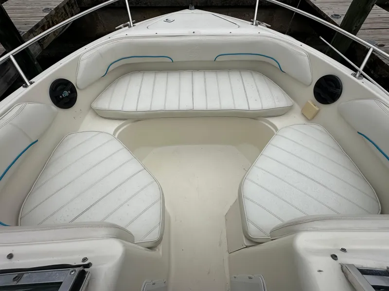 Slide: The Image of 1997 Sea Ray Laguna 21 boat interior with white cushioned seating. - 12