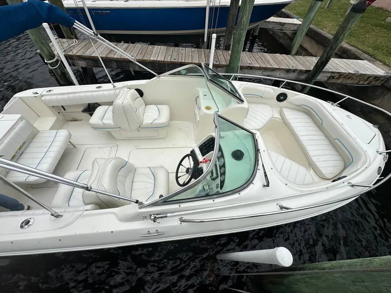 Slide: The Image of 1997 Sea Ray Laguna 21 boat with white seating, docked at a marina. - 13