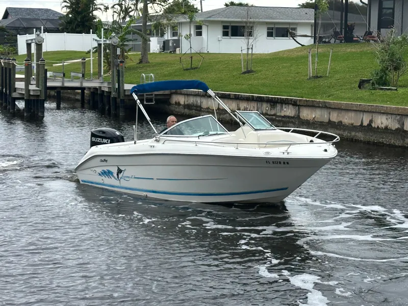 Slide: The Image of 1997 Sea Ray Laguna 21 boat cruising on a canal near residential area. - 3