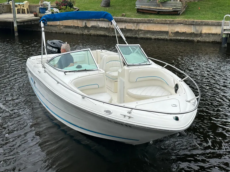 Slide: The Image of 1997 Sea Ray Laguna 21 boat with blue canopy on calm water. - 4