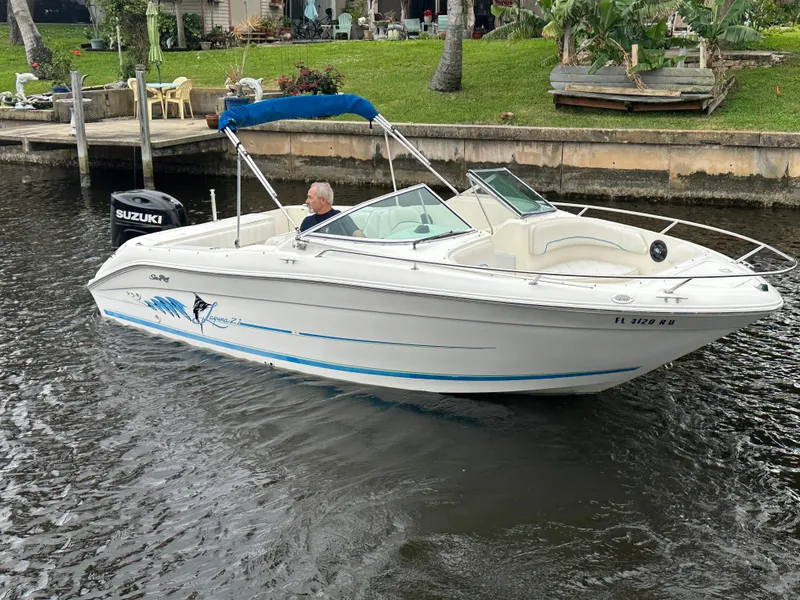 Slide: The Image of 1997 Sea Ray Laguna 21 boat with Suzuki outboard motor on a calm waterway. - 5