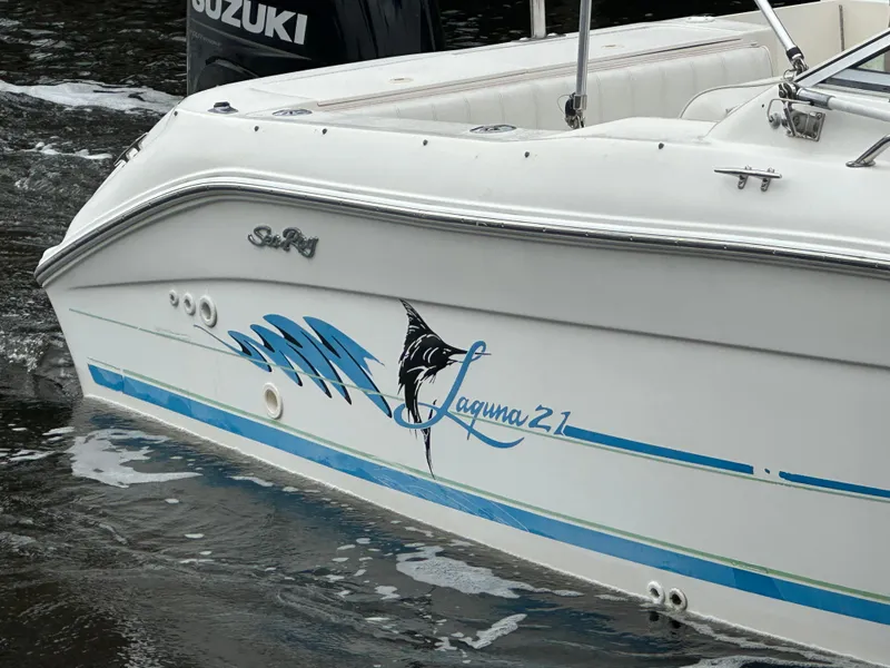 Slide: The Image of 1997 Sea Ray Laguna 21 boat with blue wave graphics on the water. - 7