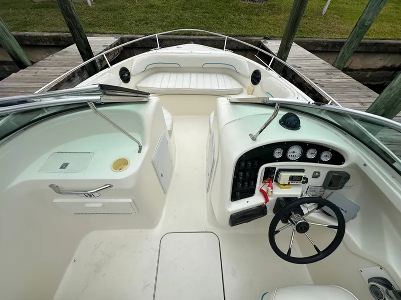 Slide: The Image of 1997 Sea Ray Laguna 21 boat interior with steering wheel and dashboard, docked at a marina. - 9