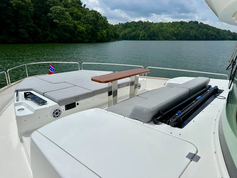 Slide: The Image of Luxurious 2021 Sirena 58 yacht deck with seating, overlooking serene lake and lush greenery. - 13