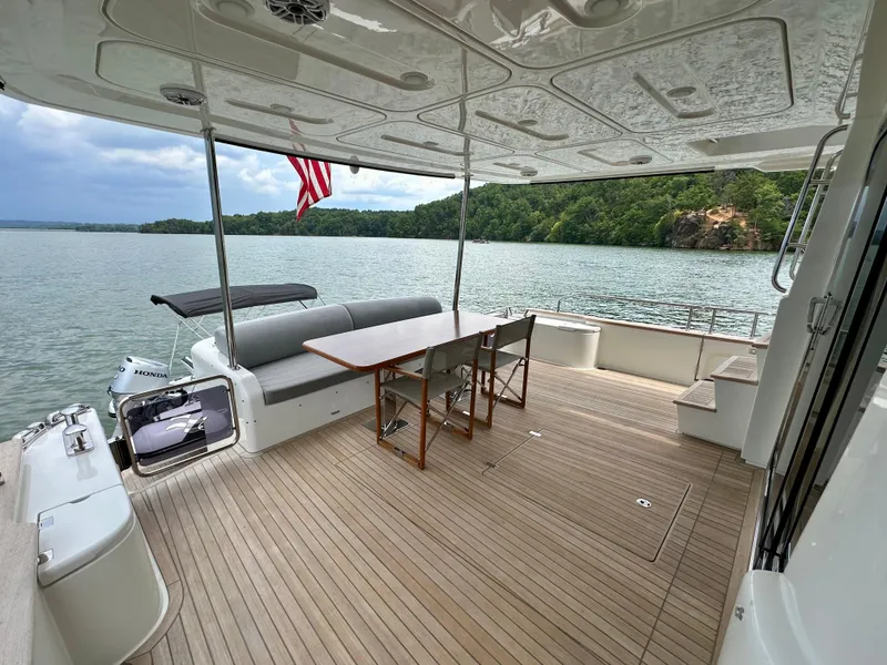 Slide: The Image of Outdoor deck of 2021 Sirena 58 yacht with seating, table, and scenic water view. - 14
