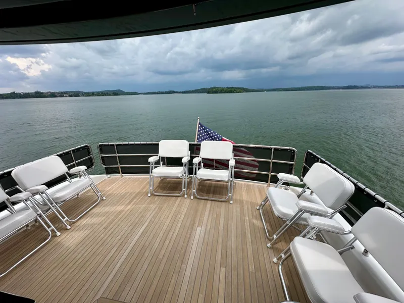 Slide: The Image of Deck of 2021 Sirena 58 yacht with chairs, overlooking serene lake and cloudy sky. - 16