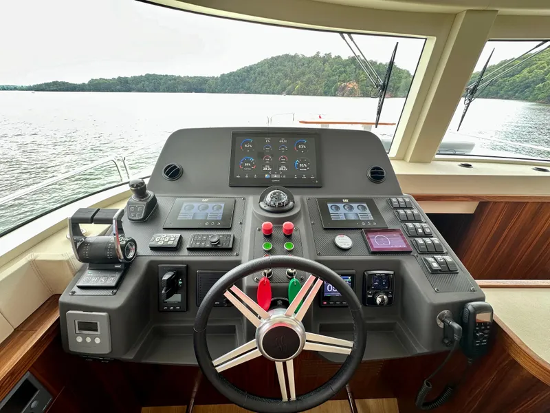 Slide: The Image of Helm of 2021 Sirena 58 yacht with advanced navigation controls and scenic water view. - 42