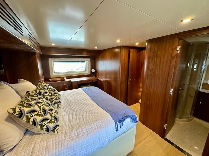 Slide: The Image of Luxurious Sirena 58 yacht bedroom interior, 2021 model, featuring elegant wood paneling and cozy bedding. - 47