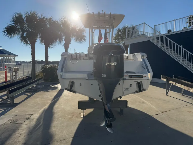 Slide: The Image of 2021 Robalo R230 Center Console boat with Yamaha 250 engine, docked under palm trees. - 3