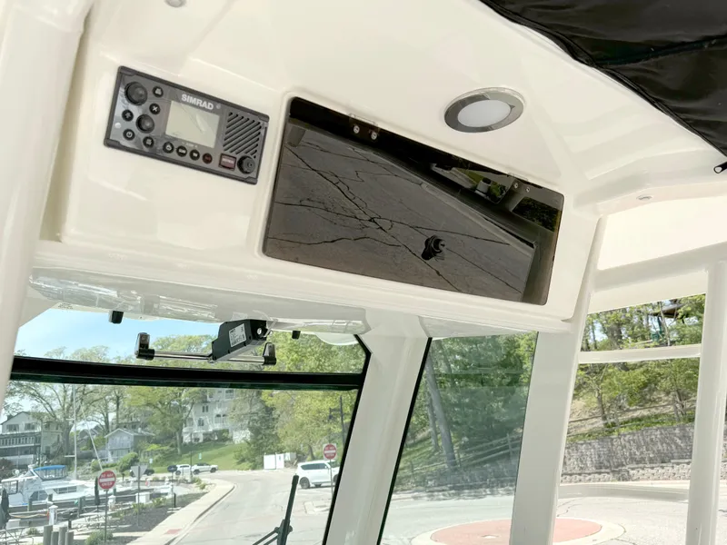 Slide: The Image of 2024 Boston Whaler 330 Outrage boat interior with control panel and window view. - 12