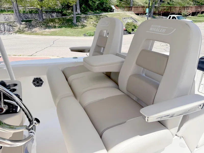 Slide: The Image of 2024 Boston Whaler 330 Outrage boat seats with armrests and steering wheel. - 21