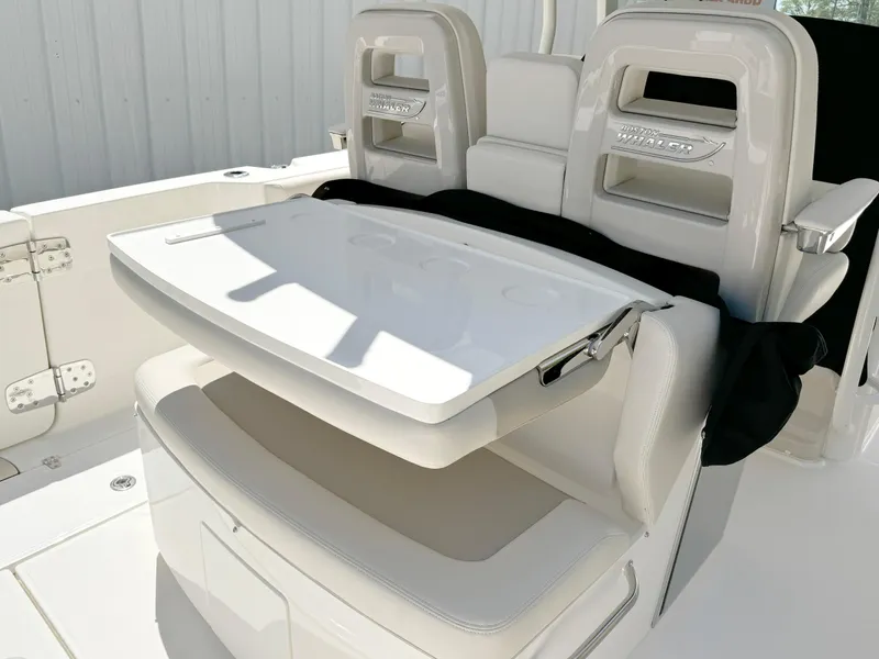 Slide: The Image of 2024 Boston Whaler 330 Outrage boat seating with foldable table and storage. - 23