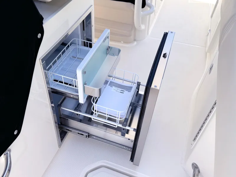 Slide: The Image of 2024 Boston Whaler 330 Outrage interior with open storage compartments. - 26
