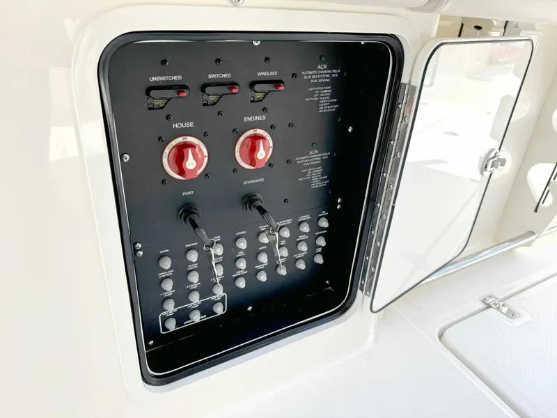 Slide: The Image of Electrical control panel on 2024 Boston Whaler 330 Outrage boat, featuring switches and dials. - 27