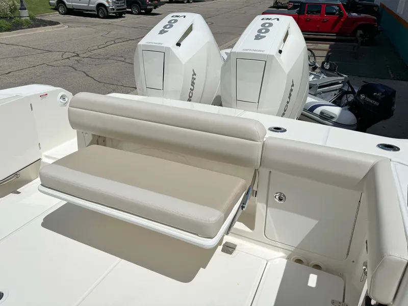 Slide: The Image of 2024 Boston Whaler 330 Outrage boat with dual Mercury engines and beige seating. - 29