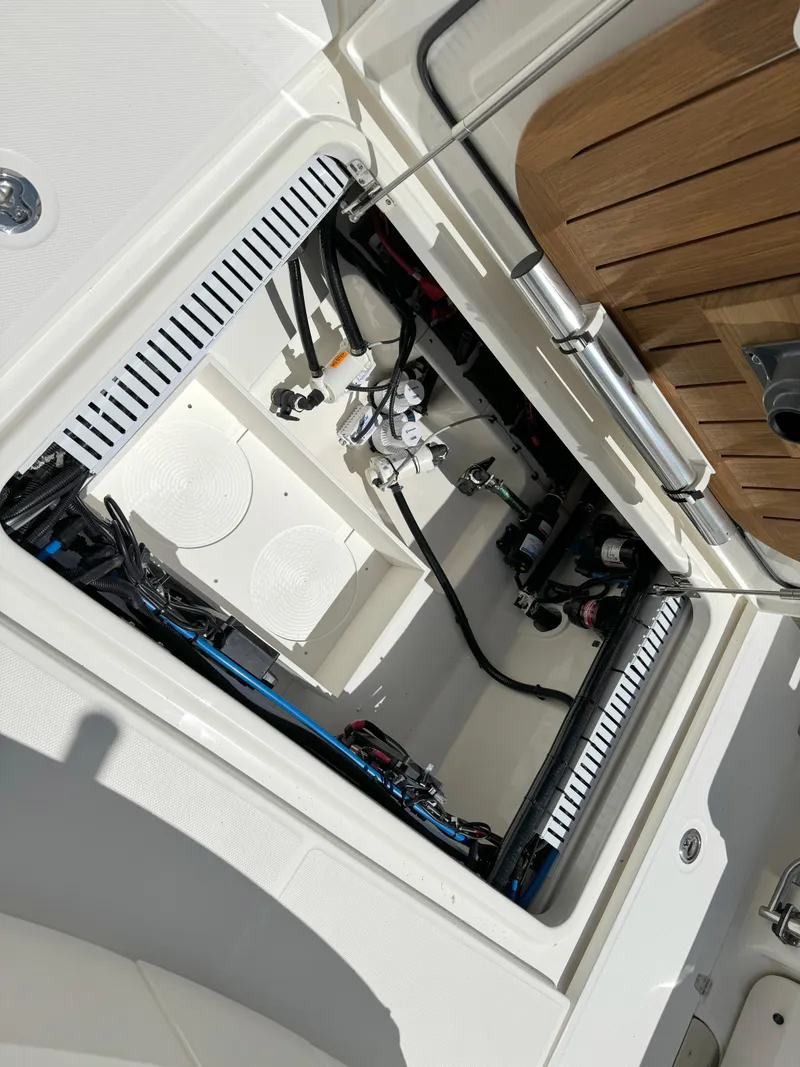 Slide: The Image of 2024 Boston Whaler 330 Outrage boat compartment with visible wiring and components. - 30