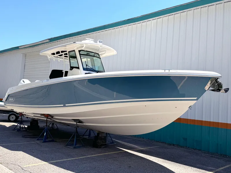 Slide: The Image of 2024 Boston Whaler 330 Outrage boat displayed outdoors on stands. - 4