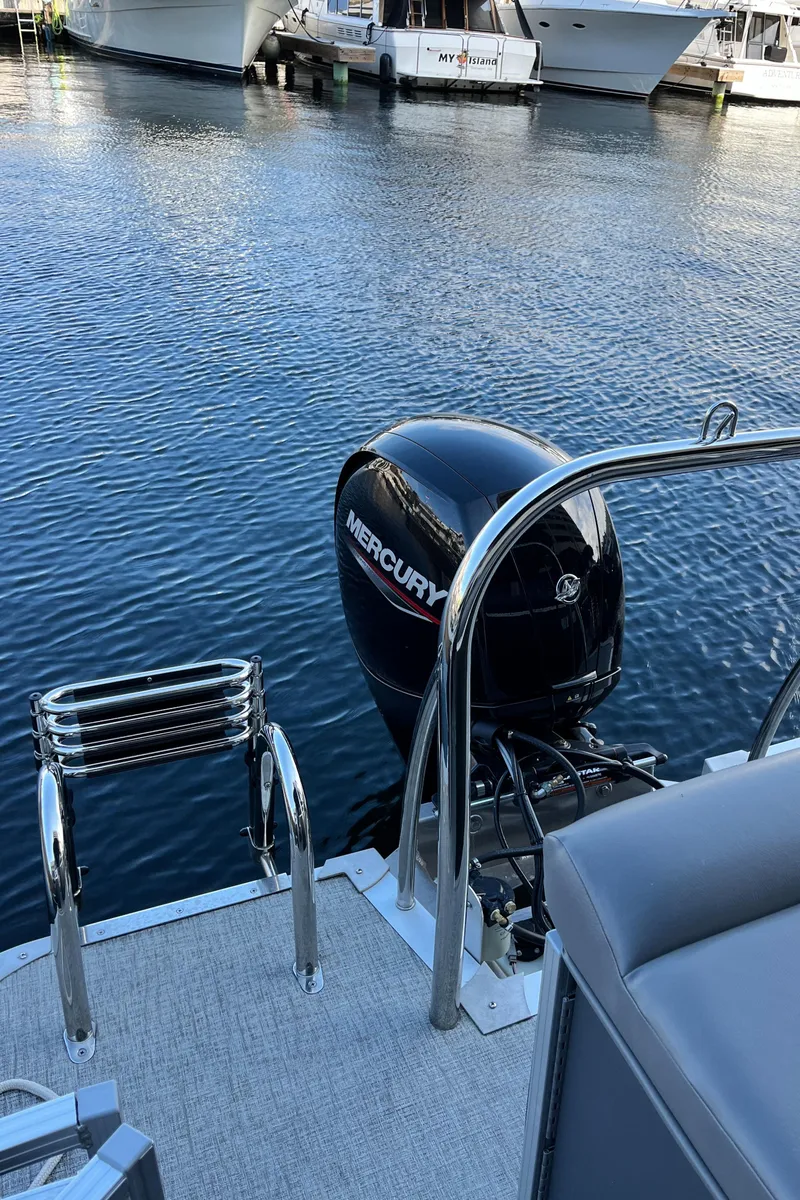 Slide: The Image of 2023 Tahoe Pontoon LTZ Cruise with Mercury outboard motor on a calm waterway. - 6