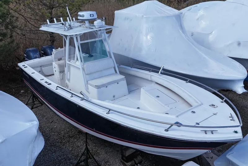 Slide: The Image of 2004 Regulator 26FS boat with T-top, docked and covered nearby. - 0