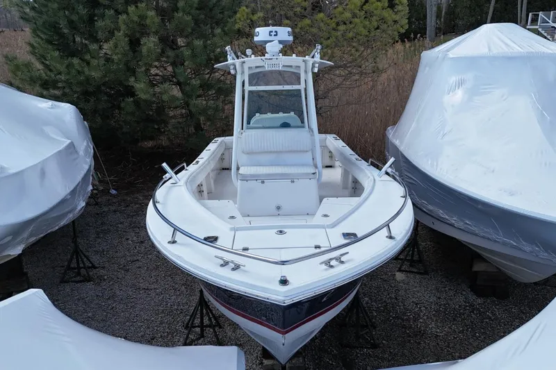 Slide: The Image of 2004 Regulator 26FS boat in storage, surrounded by covered vessels. - 1