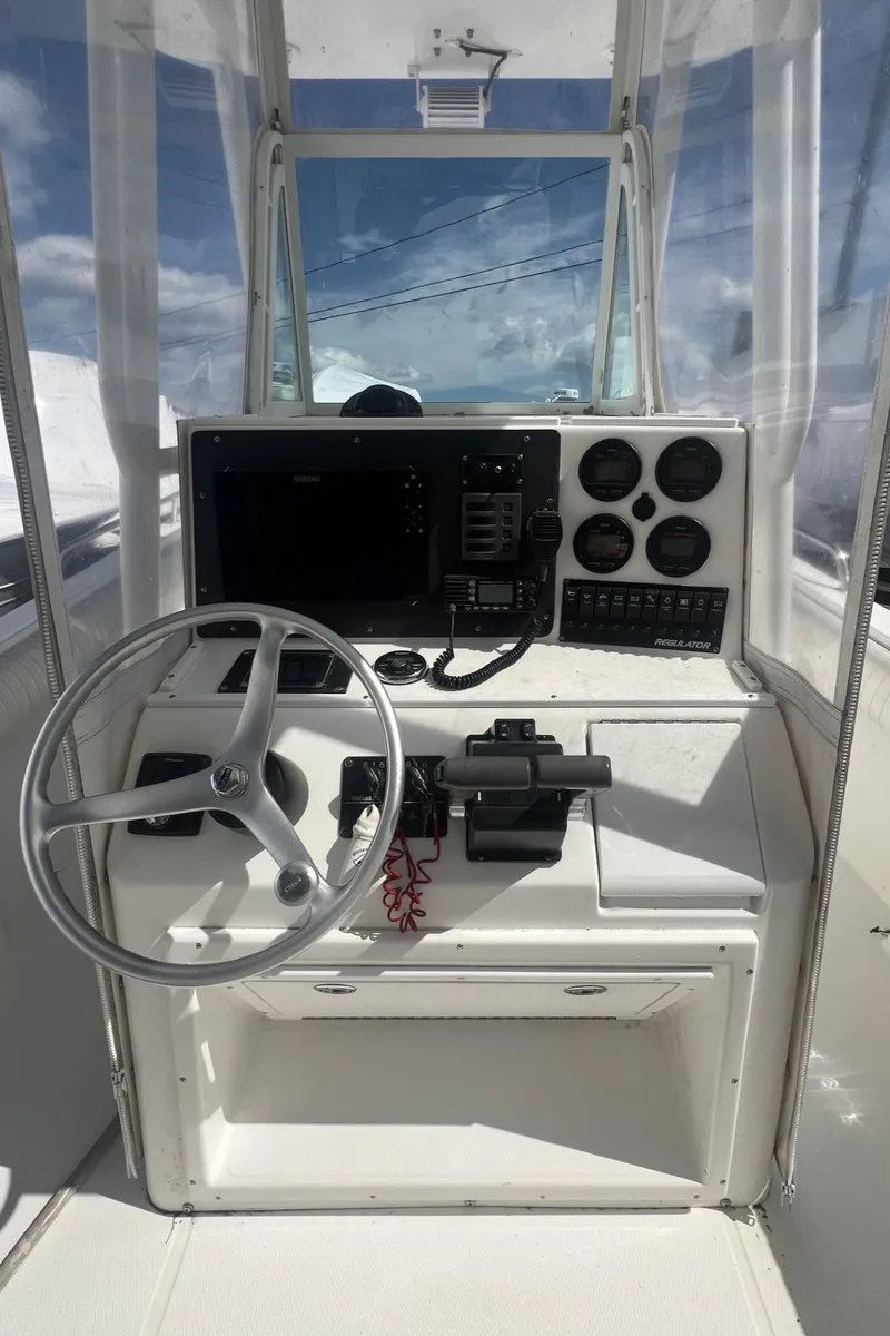 Slide: The Image of 2004 Regulator 26FS boat console with steering wheel, gauges, and navigation equipment. - 11