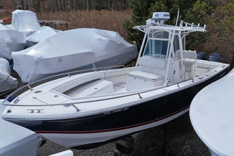 Slide: The Image of 2004 Regulator 26FS boat with T-top and radar, docked outdoors. - 2