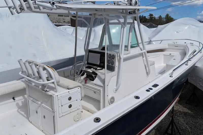Slide: The Image of 2004 Regulator 26FS boat with center console and rod holders, docked and covered. - 6