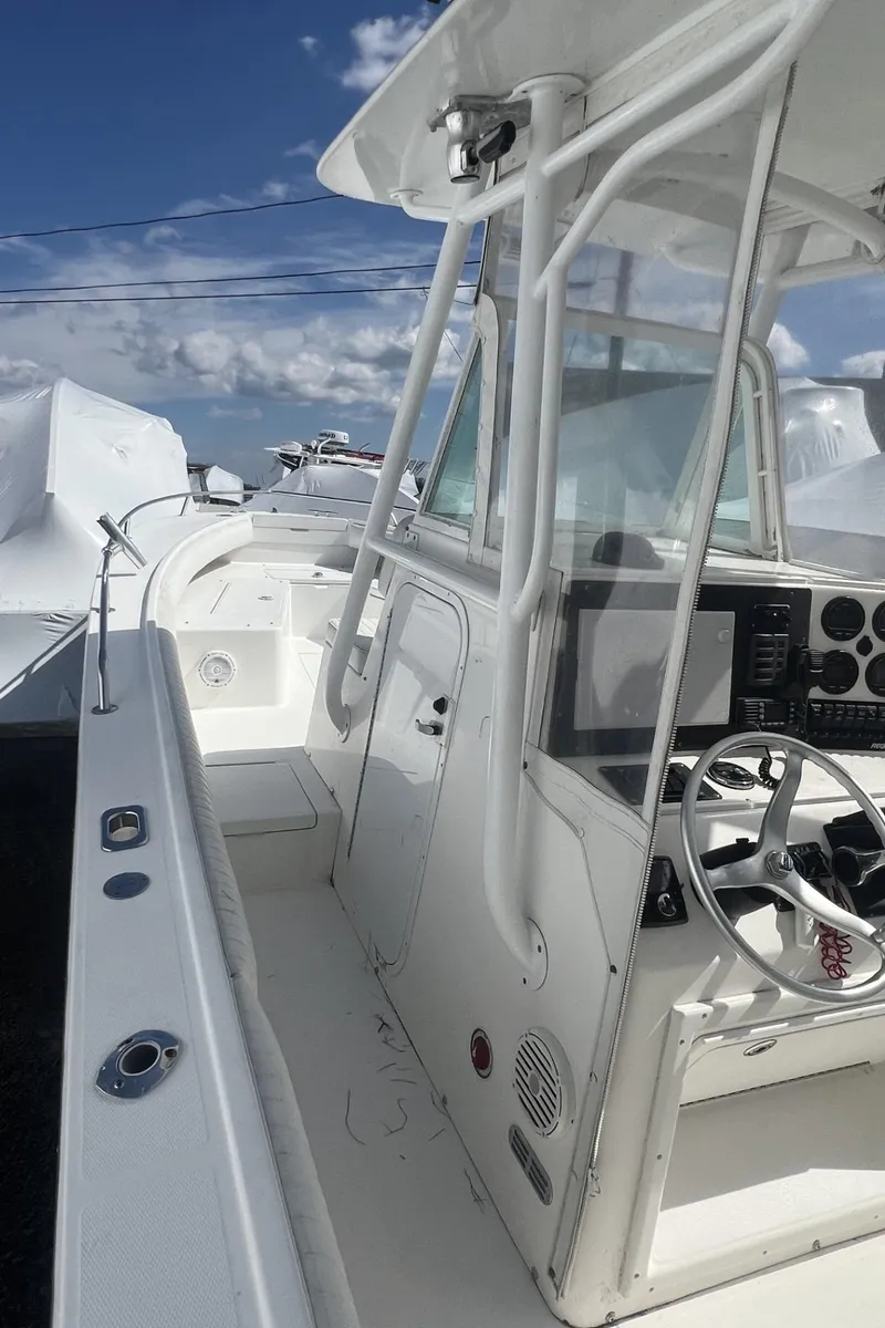 Slide: The Image of 2004 Regulator 26FS boat with white console and steering wheel under a clear blue sky. - 7