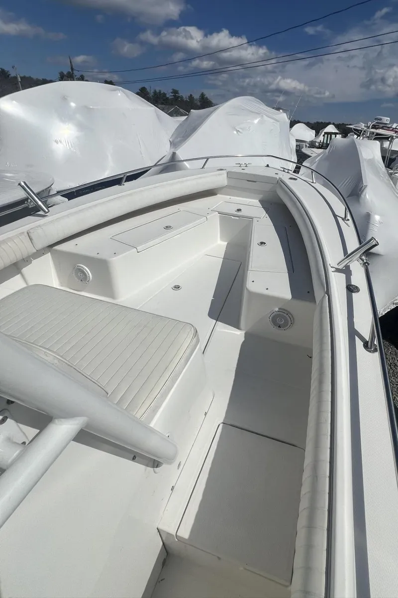 Slide: The Image of 2004 Regulator 26FS boat deck with seating, under a clear blue sky. - 8
