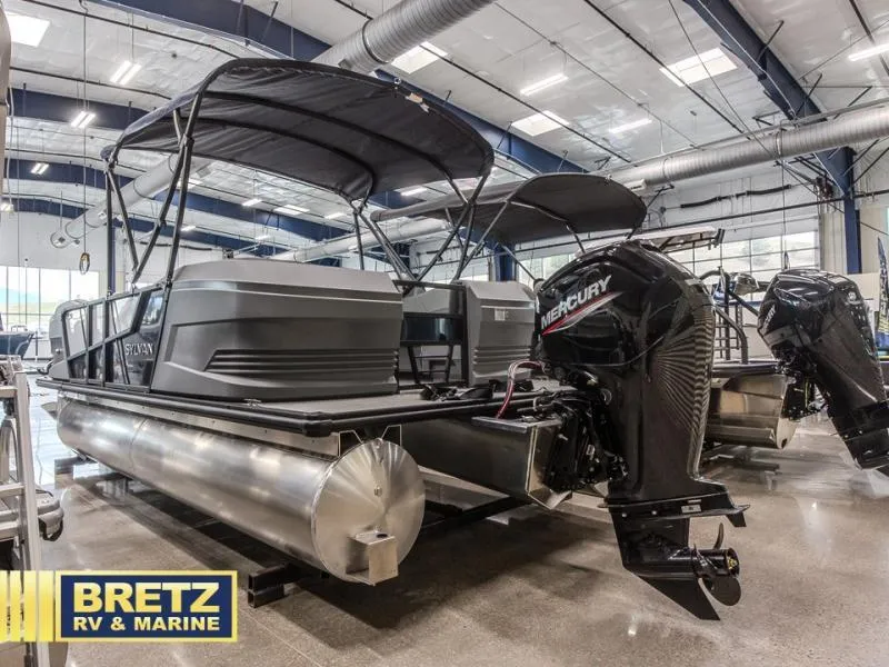 Slide: The Image of Pontoon boat in showroom with Mercury outboard motor, Bretz RV & Marine branding. - 5
