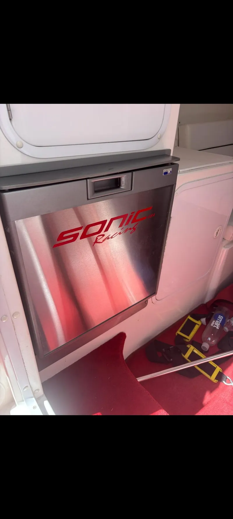 Slide: The Image of 2001 Sonic 31 SS boat interior with branded mini fridge and red accents. - 12