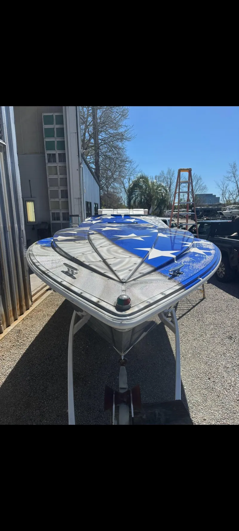 Slide: The Image of 2001 Sonic 31 SS boat with blue and white design, parked outdoors. - 4