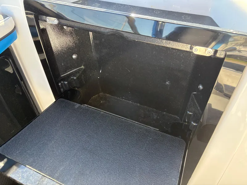 Slide: The Image of 2019 Yamaha Boats 242X E-Series storage compartment, open and empty, with black interior. - 12