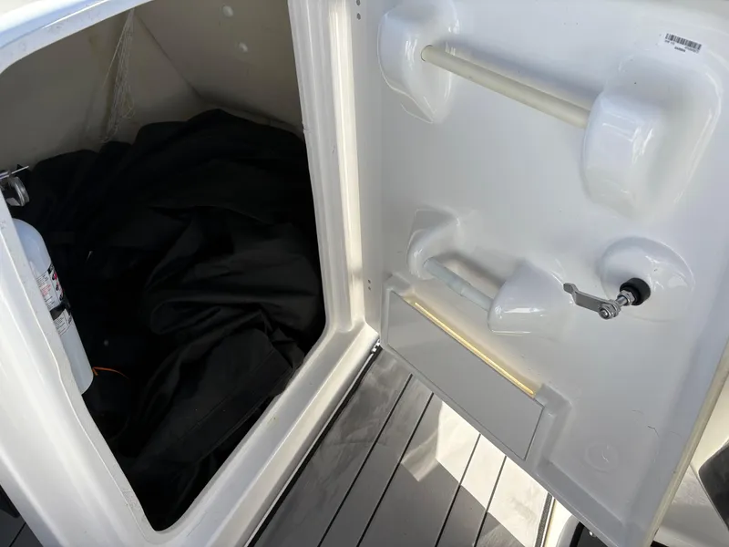 Slide: The Image of Storage compartment of 2019 Yamaha Boats 242X E-Series, featuring interior and fire extinguisher. - 17