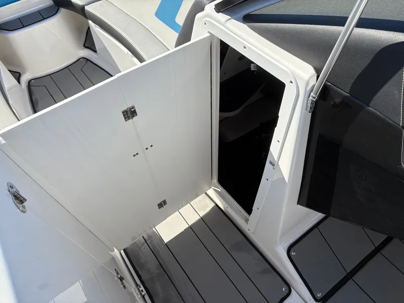 Slide: The Image of 2019 Yamaha Boats 242X E-Series interior storage compartment with open door. - 18