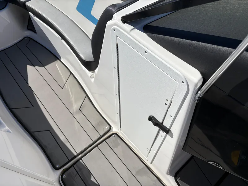 Slide: The Image of 2019 Yamaha Boats 242X E-Series interior with sleek seating and storage compartment. - 19