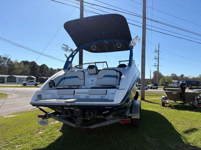 Slide: The Image of 2019 Yamaha Boats 242X E-Series on trailer, parked outdoors under clear sky. - 2