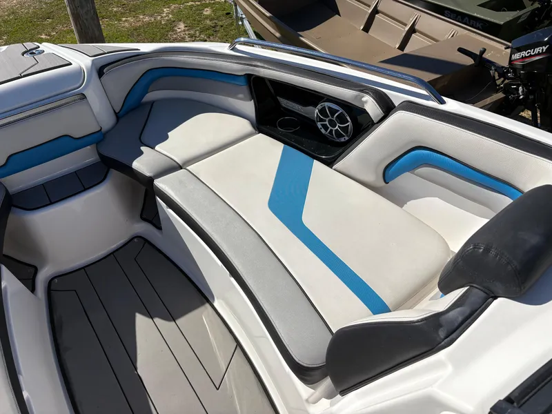 Slide: The Image of 2019 Yamaha Boats 242X E-Series interior with blue and white seating and speaker system. - 21